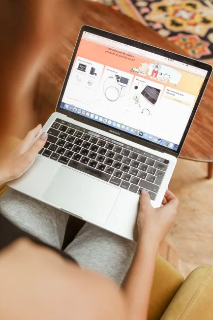 Business professional using a tablet and laptop with a hot drink, focusing on digital content review.